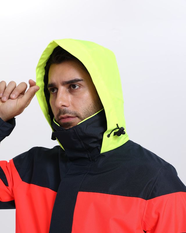 Hi-vis yellow lined hood with a drawcord and cord lock above a high collar on a navy and coral shell jacket